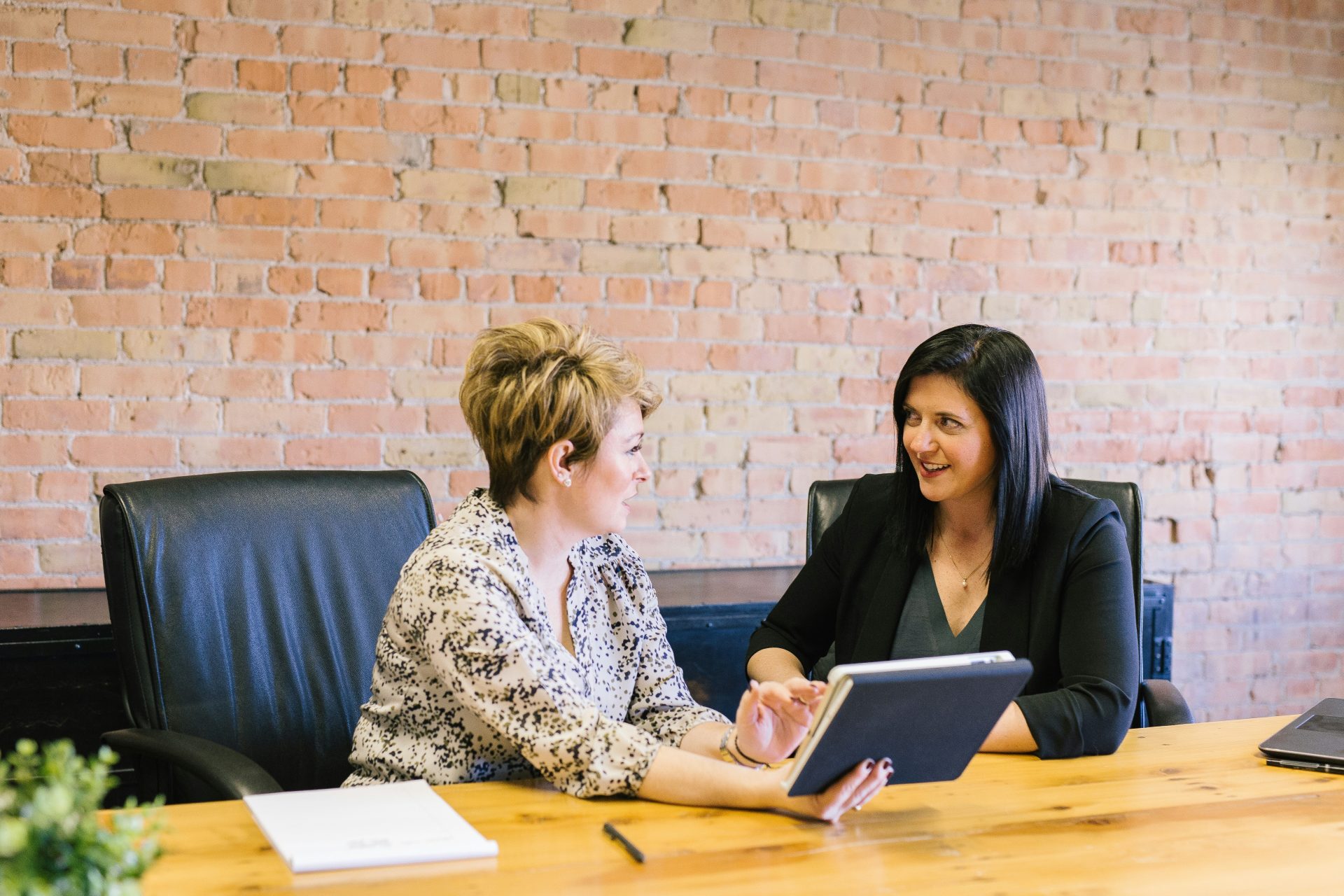 Two women discussing work with a tablet.